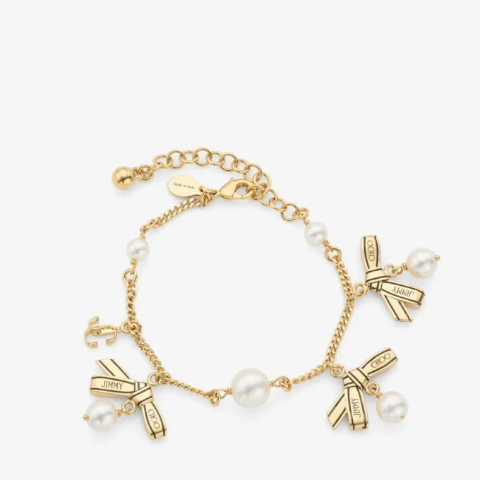 Armband med flera berlocker i form av band Armband i guldmetall med band och pärlor Armband med flera berlocker i form av band Armband i guldmetall med band och pärlor