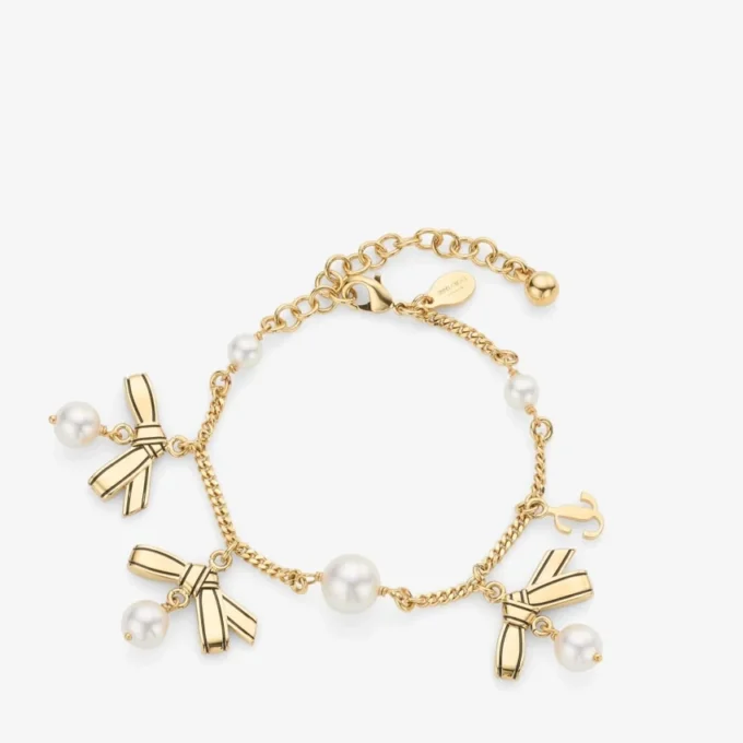 Armband med flera berlocker i form av band Armband i guldmetall med band och pärlor Armband med flera berlocker i form av band Armband i guldmetall med band och pärlor