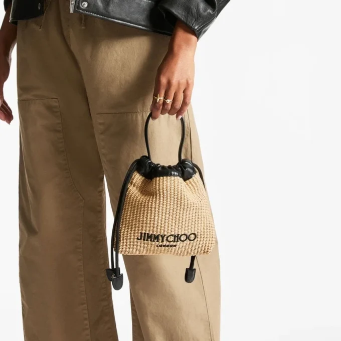 Dragsko-påse med handtag i naturfärgad och svart mjuk raffia med läderkant Dragsko-påse med handtag i naturfärgad och svart mjuk raffia med läderkant