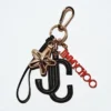 Jc Multi Charm Svart & orange kalvskinnsväskberlock med stjärnlogotyp Jc Multi Charm Svart & orange kalvskinnsväskberlock med stjärnlogotyp