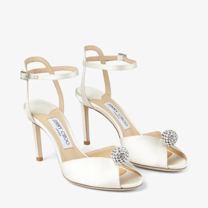 Sacora 85 sandaler i elfenbensfärgad satin med kristallprydd sfär
