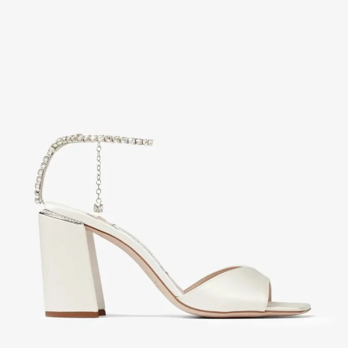 Saeda-sandal med blockklack 85 Sandaler i elfenbensfärgad satin med blockklack och kristallkedja Saeda-sandal med blockklack 85 Sandaler i elfenbensfärgad satin med blockklack och kristallkedja